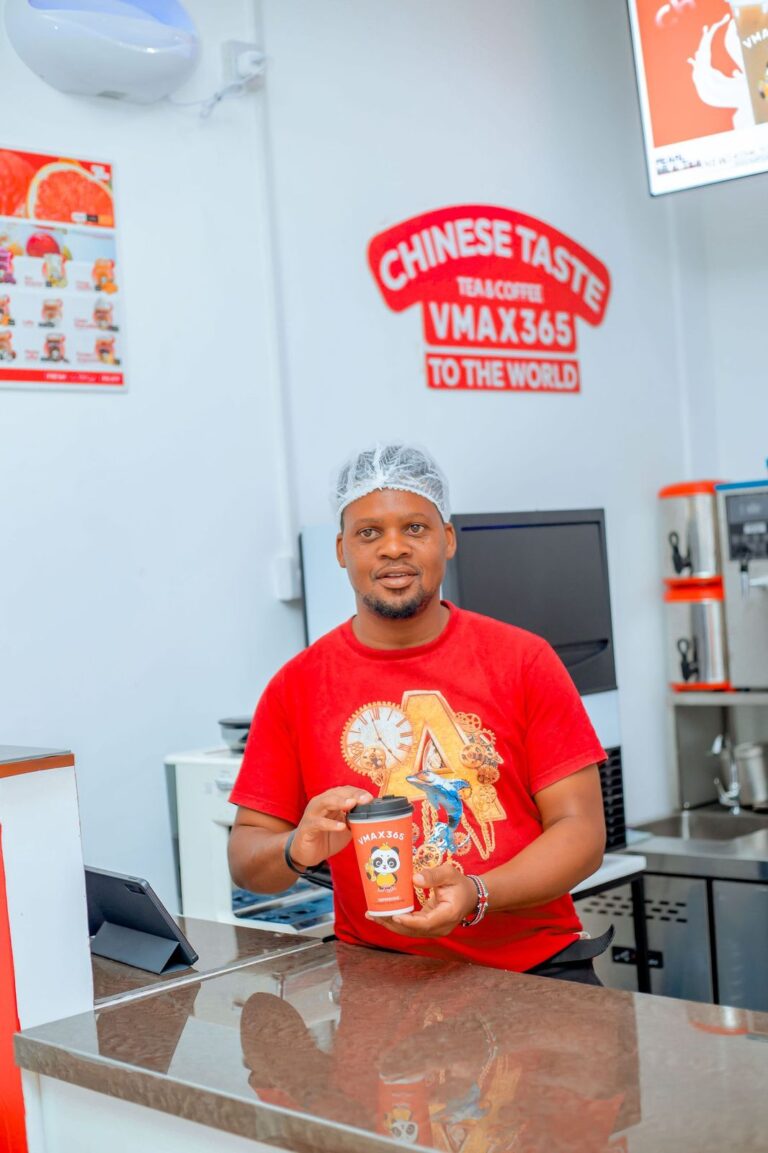 VMAX365 Tea & Coffee host holding a freshly made panda-cup drink at the Shamo Tower counter