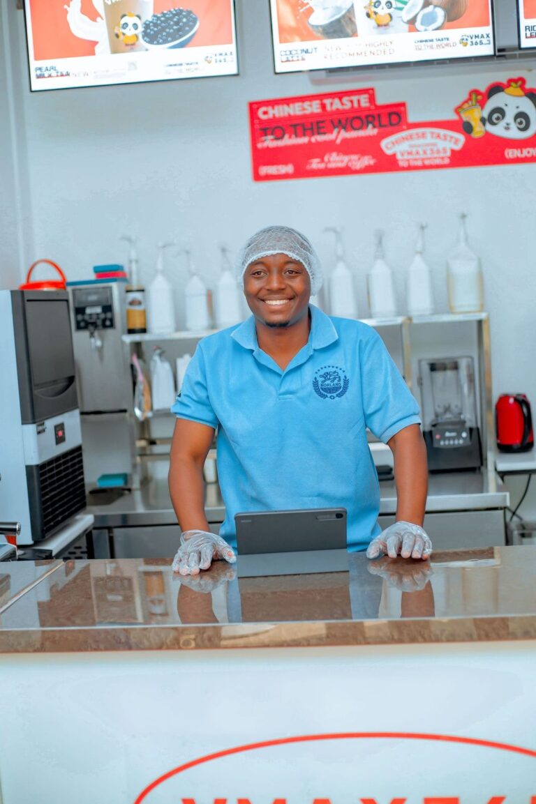 Friendly VMAX365 Tea & Coffee staff member at the Shamo Tower service counter, Mbezi Beach